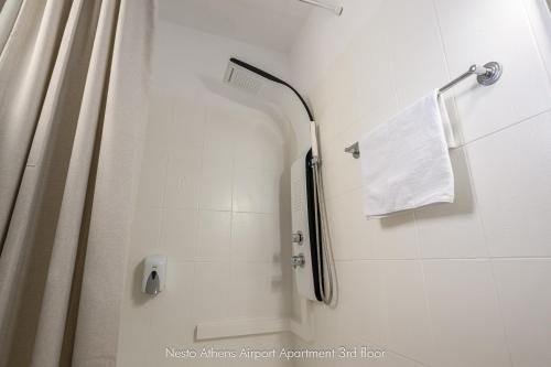 a bathroom with a shower with a shower curtain at Nesto Athens Airport in Spáta