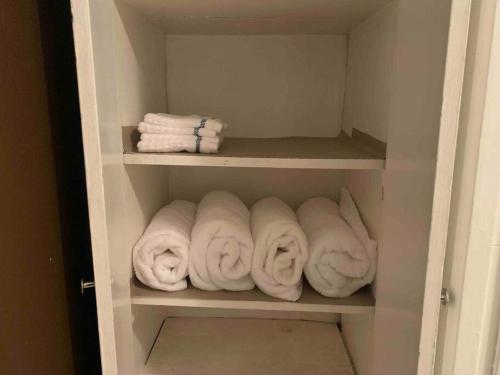 um armário cheio de toalhas brancas nas prateleiras em The Navy 2 em Oswego