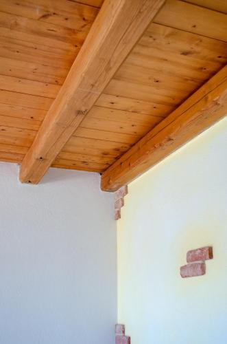 a wooden ceiling on top of a white wall at La Minditta in San Teodoro