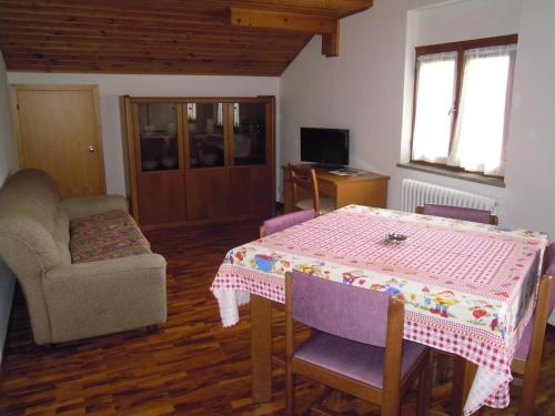 un soggiorno con un tavolo e un divano di Appartamenti Rosenberger a Molveno