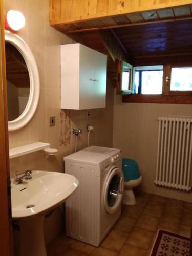 a bathroom with a washing machine and a sink at Appartamenti Rosenberger in Molveno