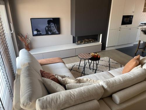 a living room with a white couch and a fireplace at -AYANA SUITE- 2 BEDROOM SUITE WITH GARAGE KNOKKE in Knokke-Heist