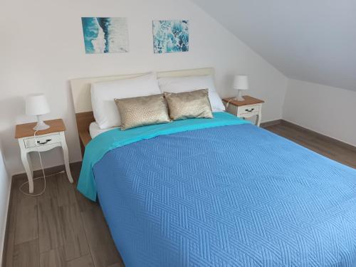 1 dormitorio con 1 cama azul y 2 mesitas de noche en Apartment Teuta, en Isla Žirje