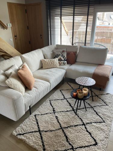 a living room with a white couch and a table at -AYANA SUITE- 2 BEDROOM SUITE WITH GARAGE KNOKKE in Knokke-Heist