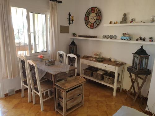 ein Esszimmer mit einem Tisch und einer Uhr an der Wand in der Unterkunft Belvilla by OYO Casa Kola in Moraira