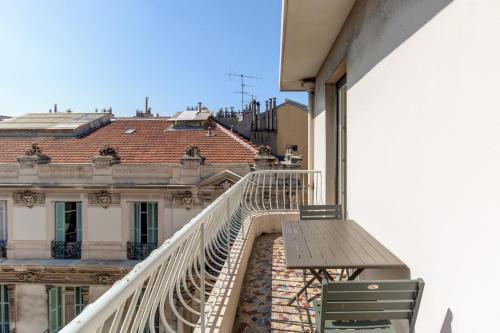 un balcon avec une table et des chaises sur un immeuble dans l'établissement Nice Gambetta, Beach, Tram, Park Alsace-Lorraine, à Nice