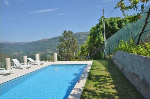 a swimming pool with two chairs and a fence at Casa Varanda do Gerês by Gerês Casas in Terras de Bouro