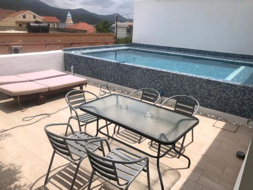 a patio with a table and chairs next to a swimming pool at METROPOLIS Argostoli House/villa with garden & pool-jacuzzi in Argostoli