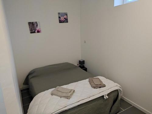 a small bed in a room with two towels on it at Apartement 'les lavandes" RdC 2CH - terrasse et parking à Lurs in Lurs