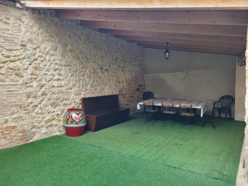 een kamer met een tafel en stoelen en een stenen muur bij Casa rural L´Amparo -3 espigas- Categoría superior-15 personas in Navarrete del Río