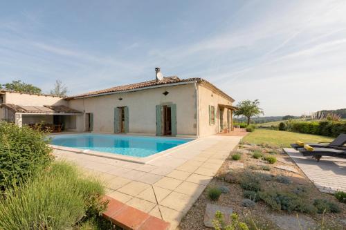 une villa avec piscine devant une maison dans l'établissement Villa avec vue - Piscine privée, cuisine d'été, jeux vidéo et appareils de fitness, à Puygaillard