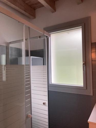 a bathroom with a window and a walk in shower at La Petite Maison-Les logis d'Agaliaure in Château-Verdun