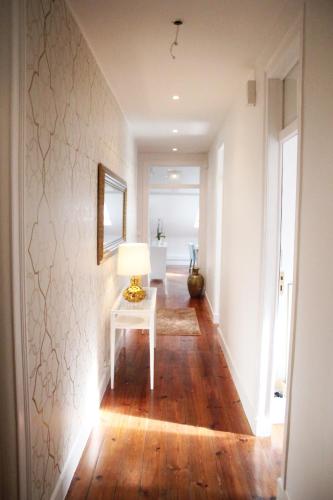 a hallway with a table and a lamp on a floor at The Sky Lofts Lisbon - Guesthouse in Lisbon