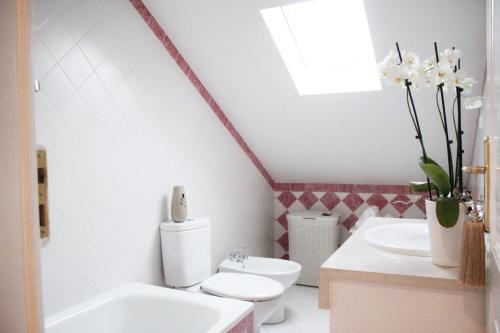 a white bathroom with a toilet and a sink at The Sky Lofts Lisbon - Guesthouse in Lisbon