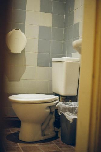 a bathroom with a toilet and a trash can at IDEAL SOCIAL Hostel in Buenos Aires