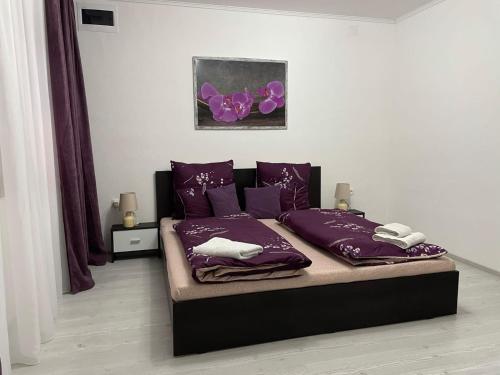 a bedroom with a bed with purple pillows at Patrik Deluxe in Gyula