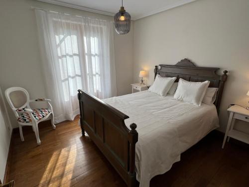 a bedroom with a large bed with white sheets at Olazahar in Donamaría