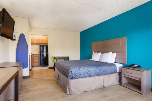 Un dormitorio con una cama y una pared azul. en One life studio and suites, en Evansville