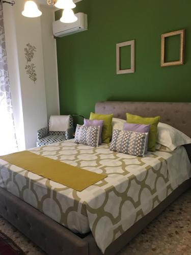 a large bed in a room with a green wall at Siracusa Vacanze in Siracusa