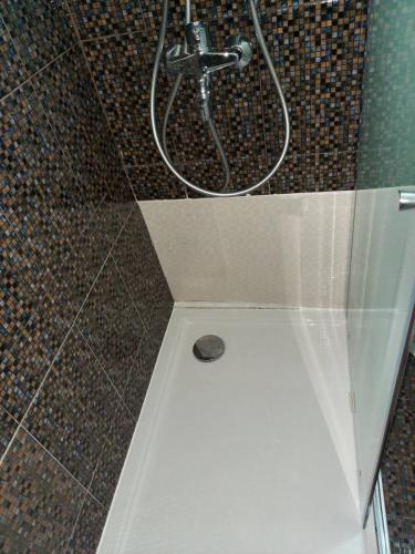 a shower in a bathroom with a shower head at Bogdanoski Studios & Guest Rooms in Ohrid