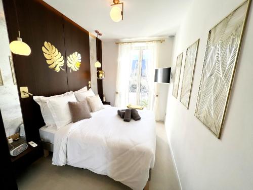 a bedroom with a large white bed and a window at La LOLA APARTMENT in Cannes