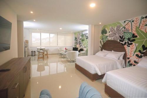 a bedroom with two beds and a living room at Edificio Casa Tabor in Barranquilla
