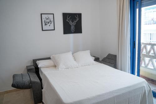 białe łóżko w pokoju z oknem w obiekcie Apartamento Puerto Playa, Fuengirola centro w mieście Fuengirola