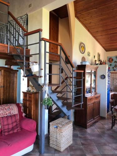 a spiral staircase in a living room with a red couch at Il tuo angolo di paradiso in Monreale