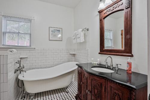 Classic Victorian home near downtown with a private pool, WiFi, & washer/dryer في سانت أوغيستين: حمام مزود بحوض استحمام ومغسلة ومرآة