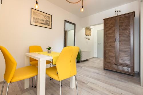 a dining room with a table and yellow chairs at Bol Summer Residence in Bol