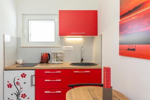 a kitchen with red cabinets and a wooden table at Bol Summer Residence in Bol