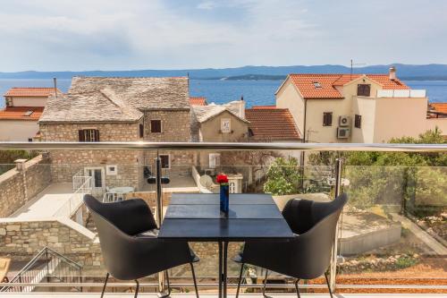 a table on a balcony with a view of the water at Bol Summer Residence in Bol