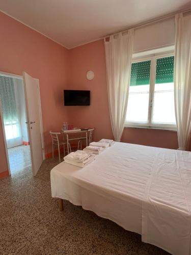 a bedroom with a large white bed and a table at Bed and coffee Rooms Portoferraio in Portoferraio