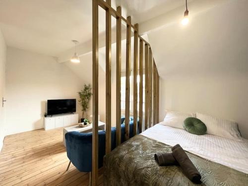 1 dormitorio con 1 cama grande y 1 silla azul en *Le cocon de Montigny*, en Montigny-sur-Loing