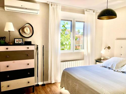 1 dormitorio con 1 cama con tocador y ventana en Adosado para familias al lado de la playa, con piscina en Castellón de la Plana