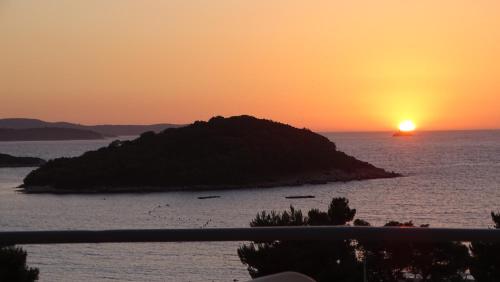 a sunset over a small island in the ocean at Hotel Ardiani in Ksamil