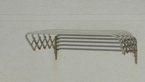 a metal bench on the side of a wall at Hotel Ardiani in Ksamil