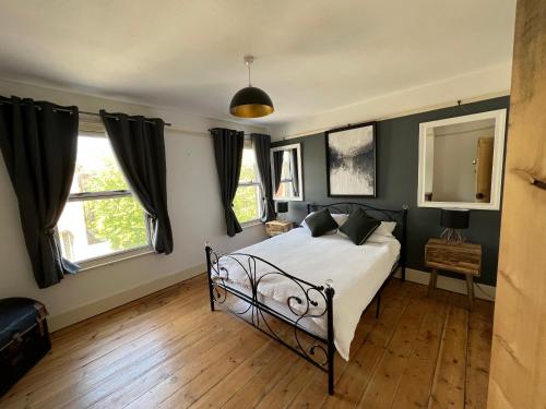 a bedroom with a bed and two windows at Charming 3 bedroom property in Bury St Edmunds in Bury Saint Edmunds
