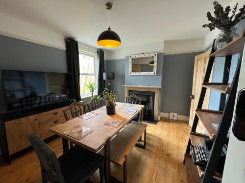 a dining room with a table and a fireplace at Charming 3 bedroom property in Bury St Edmunds in Bury Saint Edmunds
