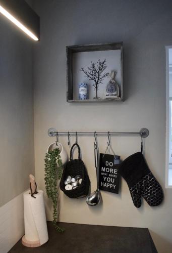a wall with a shelf and a plant and a picture at The Sybilla Apartment - cosy and modern basement apartment in Klaksvík