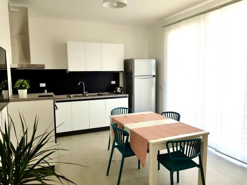a kitchen with a table and chairs and a refrigerator at Le Nasse in Fano
