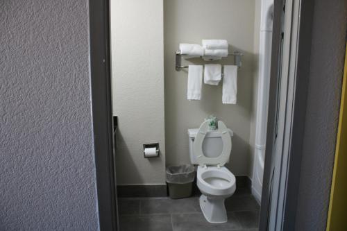 a small bathroom with a toilet and towels at Days Inn by Wyndham Waco University Area in Waco