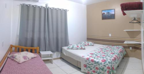 a small bedroom with a bed and a window at Apart ZSS in Penha