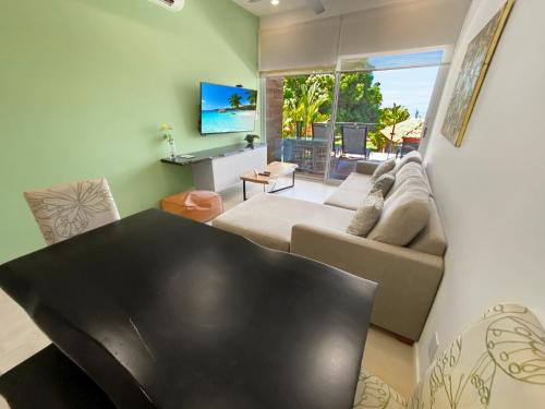 ein Wohnzimmer mit Sofa und Fernseher in der Unterkunft SUNSET OCEAN VIEW CONDO in Jacó