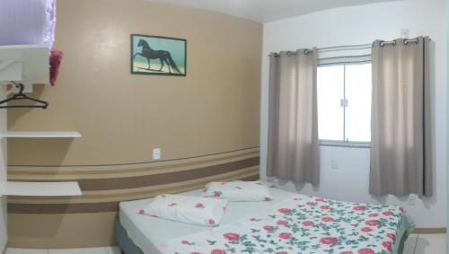 a bedroom with a bed and a picture of a horse on the wall at Apart ZSS in Penha