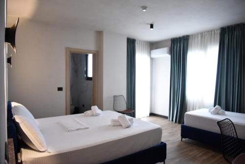 a hotel room with two beds and two chairs at Gogo's Boutique Hotel in Dhërmi