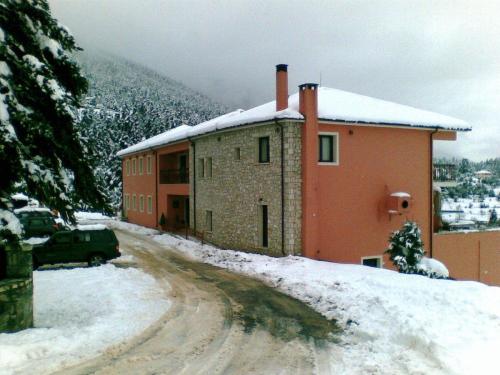 a building on a snow covered road in front at Vytina Mountain View Hotel in Vytina