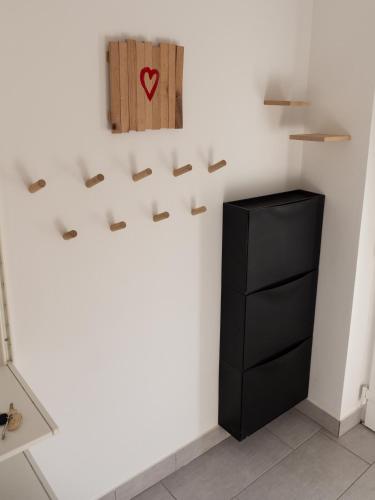 a room with a black cabinet and a heart on the wall at D&N Apartment in Ljubljana
