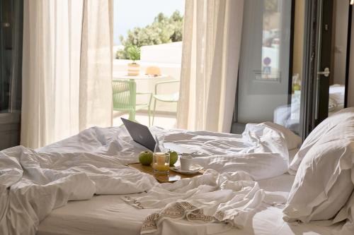 a bed with a laptop on top of it at Alleys All-Suite Hotel & Spa in Pirgos