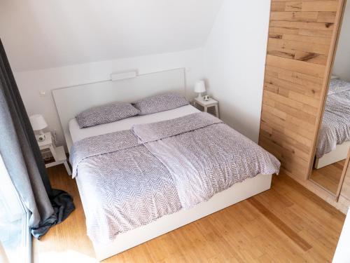 a bedroom with a white bed and a mirror at D&N Apartment in Ljubljana